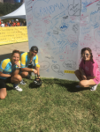 Victor Castro, CDT, at a Livestrong Austin bike race, posing with wife Angie and daughter Nicole in front of a board signed by cancer survivors.
