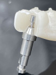 (4.) Cutaway view of a model of a direct to multi-unit abutment full-arch prosthesis connected to an implant analog and multi-unit abutment with a prosthetic screw.