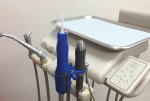 Figure 1 Aquasil Ultra Cordless digit power™ Dispenser. The impression Dispenser, with installed intraoral tip, is shown in the blue plastic adapter. To its right is the regulator attached to the dental air line. Note at the top of the regulator is a silver knob with settings for flow rate of impression material; a flow rate of 1 is the slowest, and 4 is the fastest. When the regulator sits in the tool holder as shown, the Dispenser is deactivated.