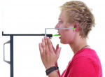 The patient places her index fingers on the support device for stabilization and looks in the mirror with a relaxed lower jaw position.
