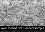 Figure 21  SEM micrograph of an over-etched but not steam-cleaned sample covered with various deposits.