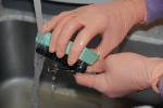 Figure 1  An example of improper glove and brush type being used during instrument cleaning.