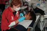 Figure 1  Cheryl Ennis, dental assistant to Dr. William Calnon (the newest ADA-president elect) serving one of the children at the event. Photo Credit: ADA News. © 2011 American Dental Association