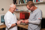 Fig 2. Wagner examines a digitally fabricated denture with his on-site laboratory technician, Samuel.